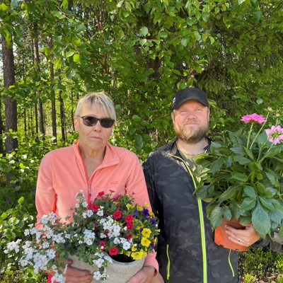En kvinna och en man står med blommor i händerna. 