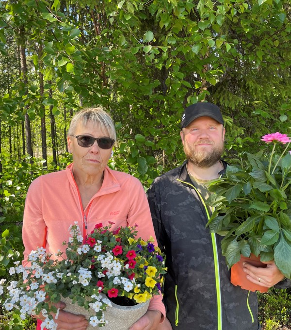 En kvinna och en man står med blommor i händerna. 