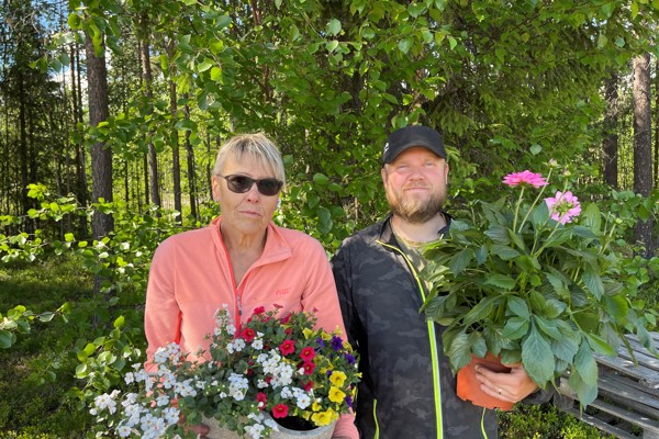 En kvinna och en man står med blommor i händerna. 