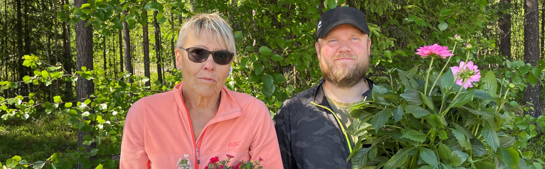 En kvinna och en man står med blommor i händerna. 