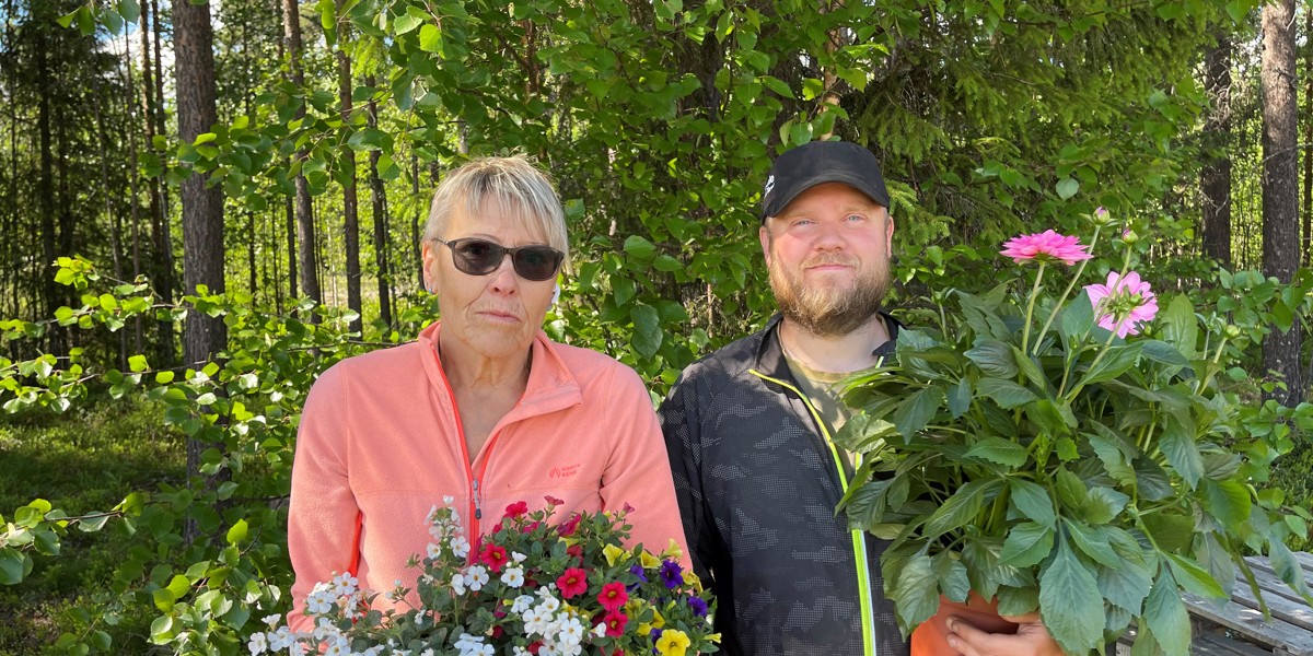 En kvinna och en man står med blommor i händerna. 