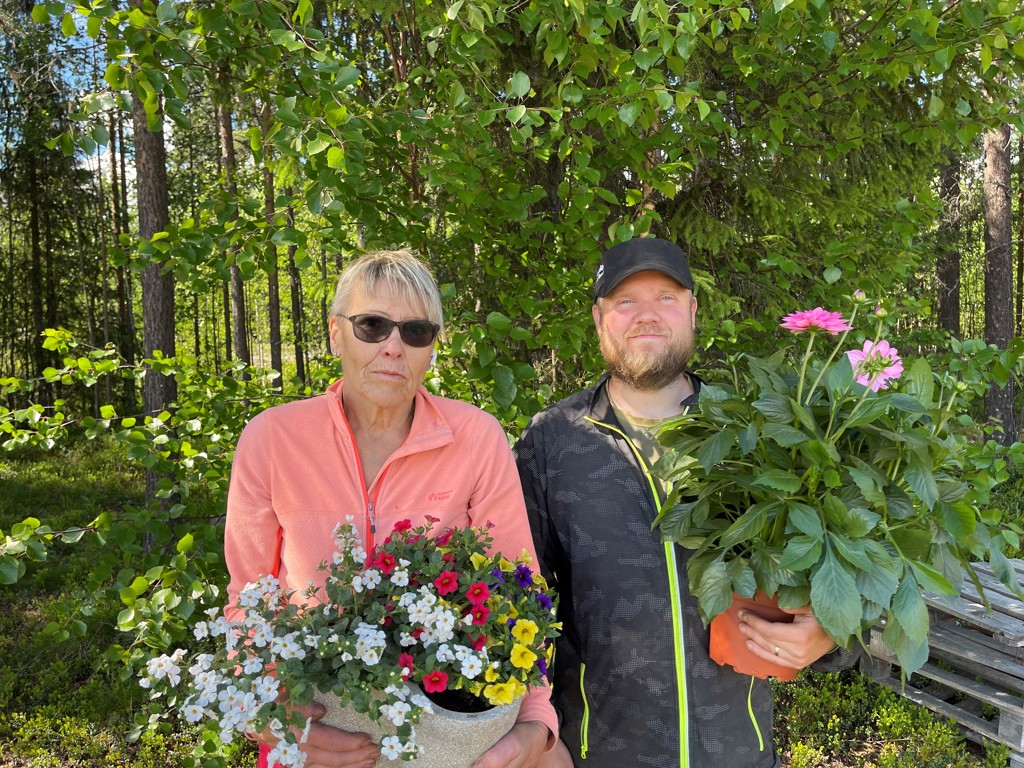 En kvinna och en man står med blommor i händerna. 