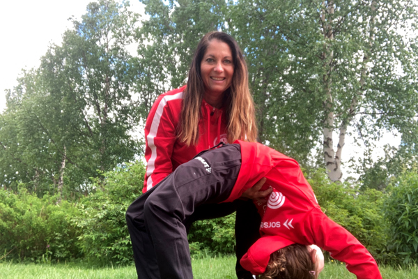 Johanna stöttar ett barn som står i brygga.