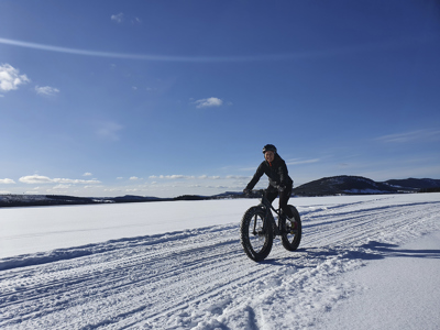 Johanna cyklar fatbike på ett skoterspår.